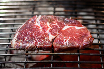 Raw rib eye beef steak meat grill on grill grid