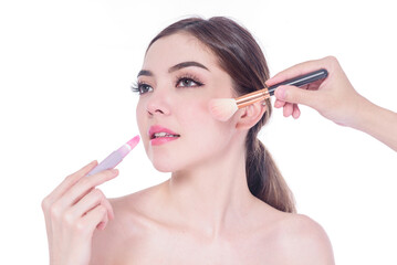 Fototapeta premium portrait of a woman applying dry cosmetic tonal foundation on the face using makeup brush isolated on white background