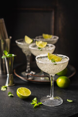 Margarita cocktail with lime and ice on dark wooden table with copy space. Classic Margarita and Daiquiri Cocktail.
