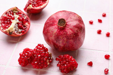 Ripe delicious pomegranate on pink tile background