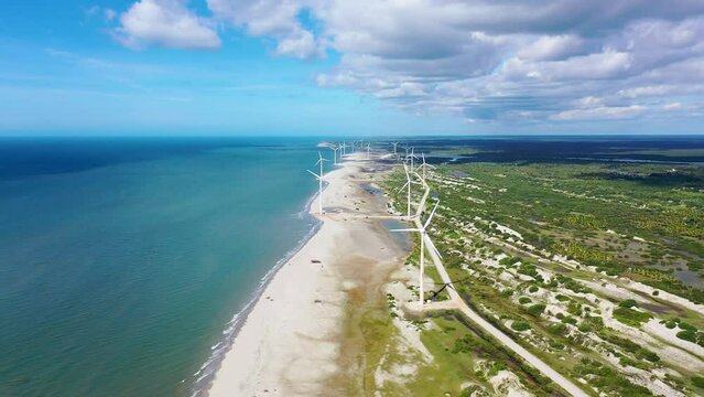 Northeast Brazil. Aeolian turbine at Beach at Ceara state. Beach with sand dunes and desert landscape. Power generation. Green energy. Wind farm field.