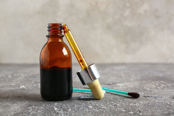 Bottle with iodine, pipette and dirty cotton swab on grunge background