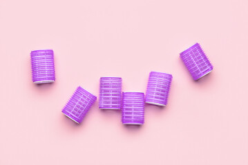 Purple hair curlers on pink background