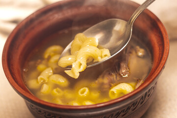 Spoon and plate with vermicelli soup and meat