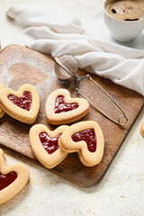 Board with tasty cookies for Valentine's Day celebration on light background