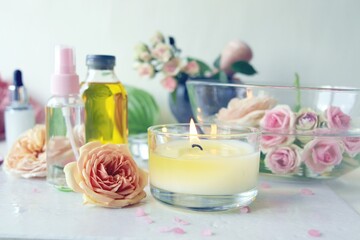 Obraz na płótnie Canvas Spa, fresh pink roses, burning candles, oils and tinctures on a light background, healthy lifestyle, relaxation, home cosmetics, aromatherapy, romantic mood, alternative medicine