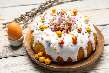 Plate with tasty Easter cake and egg on white wooden background