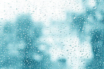 Water drops on glass on abstract blue and white background