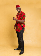 Fototapeta na wymiar Igbo Traditionally Dressed Business Man Standing and Fist Pump