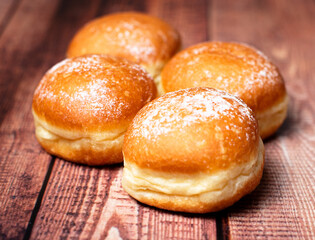 Decadent Delights: Austrian Krapfen and German Berliner, Oozing Creamy Goodness Inside. On wooden...