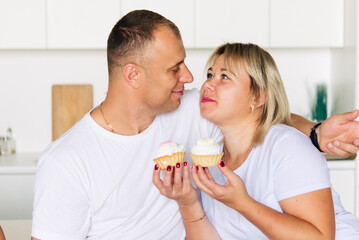 Obraz na płótnie Canvas Happy couple having cakes in the kitchen 