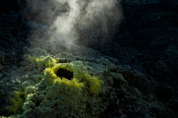 Fumarole with crystals of native sulfur. Field of fumaroles at the foot of Baranskogo volcano,...