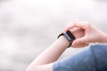 young healthy woman workout in gym fitness and watch on smart watch for setting and checking watch device for health