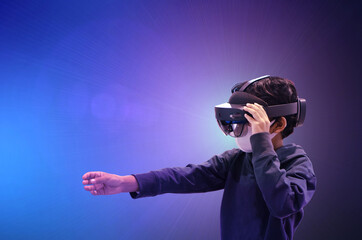 Obraz na płótnie Canvas Asian kid boy using metaverse VR virtual reality glasses