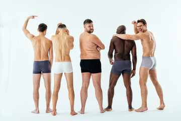 Group of multiethnic men posing for a male edition body positive beauty set. Shirtless guys with...