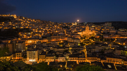 Fototapeta na wymiar Aerial View of Modica City Centre at Night with the Lunar Eclipse, Ragusa, Sicily, Italy, Europe