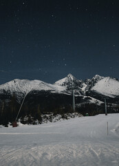 Snowy mountains of High Tatras with stars on the sky at night.