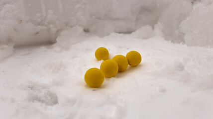 Yellow balls on a snowy background in winter.