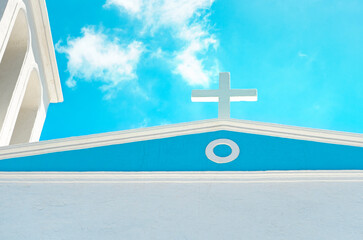 Church cross on top of roof on blue sky background