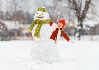 girl playing with a snowman