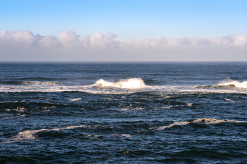 Waves breaking on the beach in Oregon with a cloudy background and Copy space.