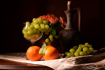 martwa natura z owocami na brązowym tle. winogron, pomarańcz, czerwone róże w kompozycji z butelka wina. kompozycja na tekstura lub tapeta na pulpit. 