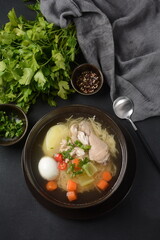 South American Caldo de Gallina chicken noodle soup with boiled egg and herbs. The classic Peruvian chicken noodle soup.