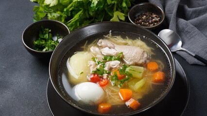 South American Caldo de Gallina chicken noodle soup with boiled egg and herbs. The classic Peruvian chicken noodle soup.