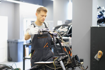 A man mechanic repairs the steering wheel of a motorcycle