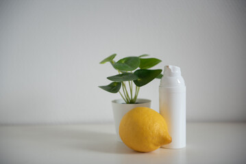 Citron, plante verte et flacon cosmétique blanc sur fond blanc - mock up cosmetique
