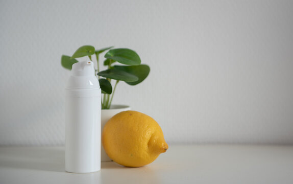Flacon cosmétique blanc avec citron et plante verte - mockup pour crème et produit de beauté