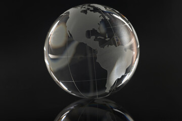 Glass globe on a black background, reflection of a circle