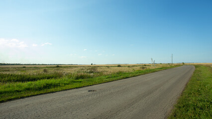 Asphalted road between two fields