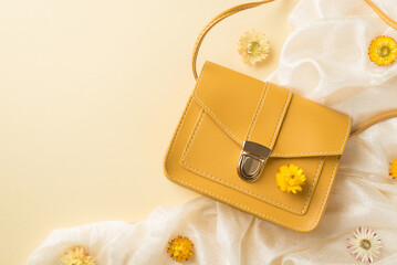Top view photo of woman's day composition yellow leather purse white scarf and wild flowers on isolated beige background with empty space