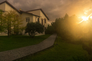 Villa, under the pre-storm clouds and the bright setting sun,