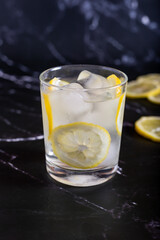 Iced glass of water and lemon on a black background