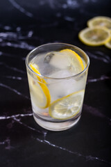 Iced glass of water and lemon on a black background
