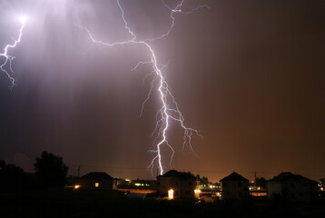 Fototapeta na wymiar large lightning strike near suburban homes
