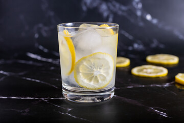 Iced glass of water and lemon on a black background