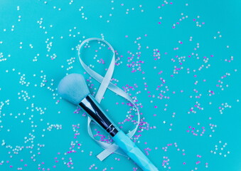 Makeup brush,Gift ribbon on a blue background with glitter,flat layot,top view