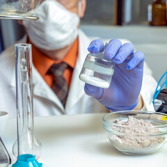 Analysis of sports nutrition in the laboratory. The inspector holds creatine in a laboratory glass...