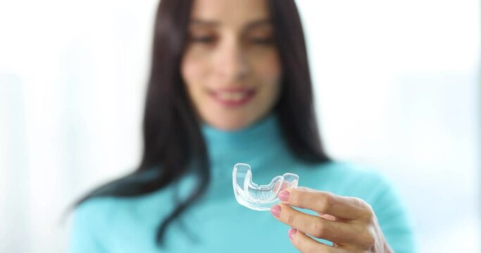 Woman holding night plastic dental cap in her hands closeup 4k movie slow motion