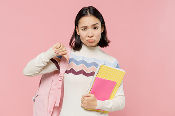 Teen student girl of Asian ethnicity wear sweater backpack hold books showing thumb down dislike...