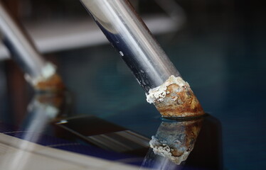 Water stone on the metal handrails of the stairs to the pool