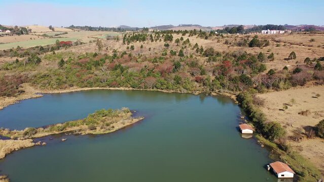 Pocos de Caldas Minas Gerais Brazil. Scenic lake with dry forest trees at edge of lake at end of winter. Great dry landscape at end of winter at rural life. Winter at rural landscape beautiful lake.