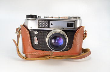 Old film camera in a leather case on a white background.