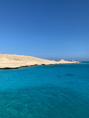 Obraz premium Sandy island near coral reef. Blue sea. 