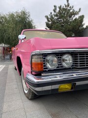 Obraz na płótnie Canvas Vertical cropped shot of a gorgeous vintage pink auto