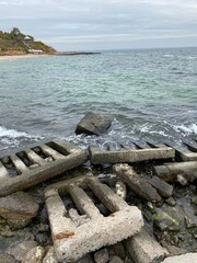 Massive broken concrete grates piled on the sea shore