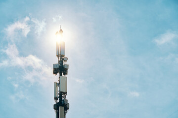 Telecommunication tower of 4G and 5G cellular. Macro base station. LTE radio network communication equipment with wireless modules and smart antennas mounted on metal on clouds sky background.